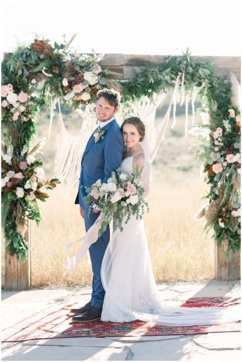 Boho floral arch with bride and groom